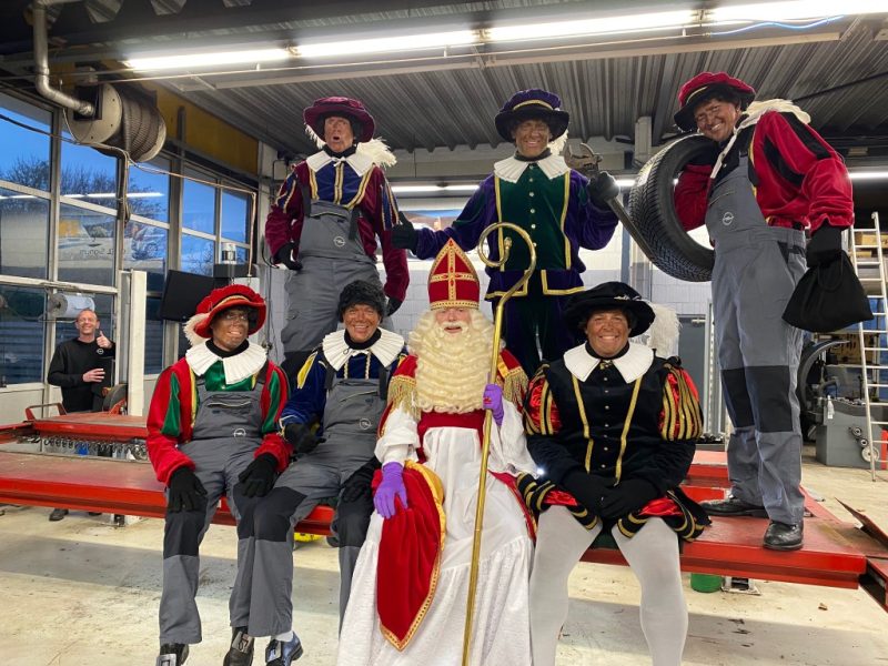 Sinterklaas en de Pieten op de foto in de garage
