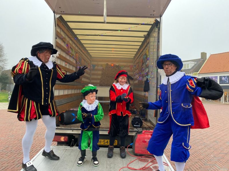 Pieten en kinderen bij de vrachtwagen met cadeautjes